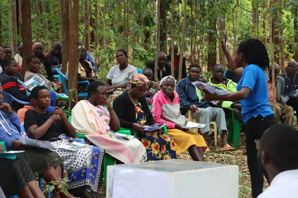 African smallholder farmers working in fields, representing the communities supported by carbon credit purchases